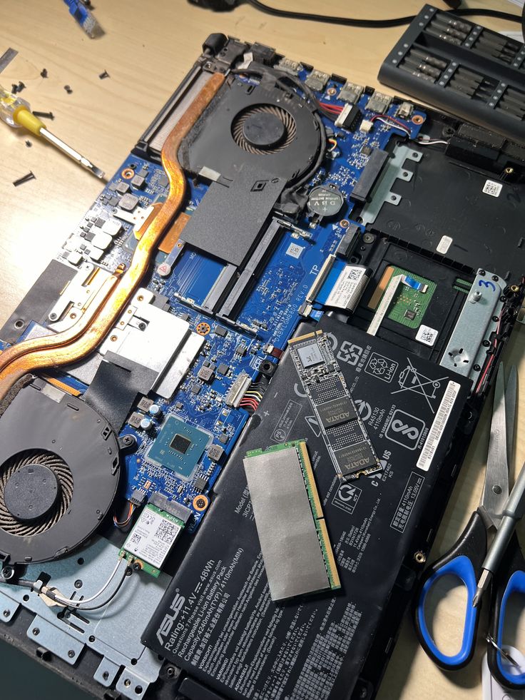 Notebook Asus aberto durante manutenção interna, com SSD, memória e sistema de refrigeração à vista
